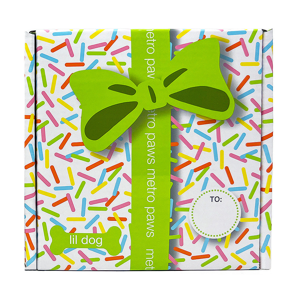 Front of Metro Pawty Box for Lil Dogs, featuring sprinkles print, lime green ribbon, and label
